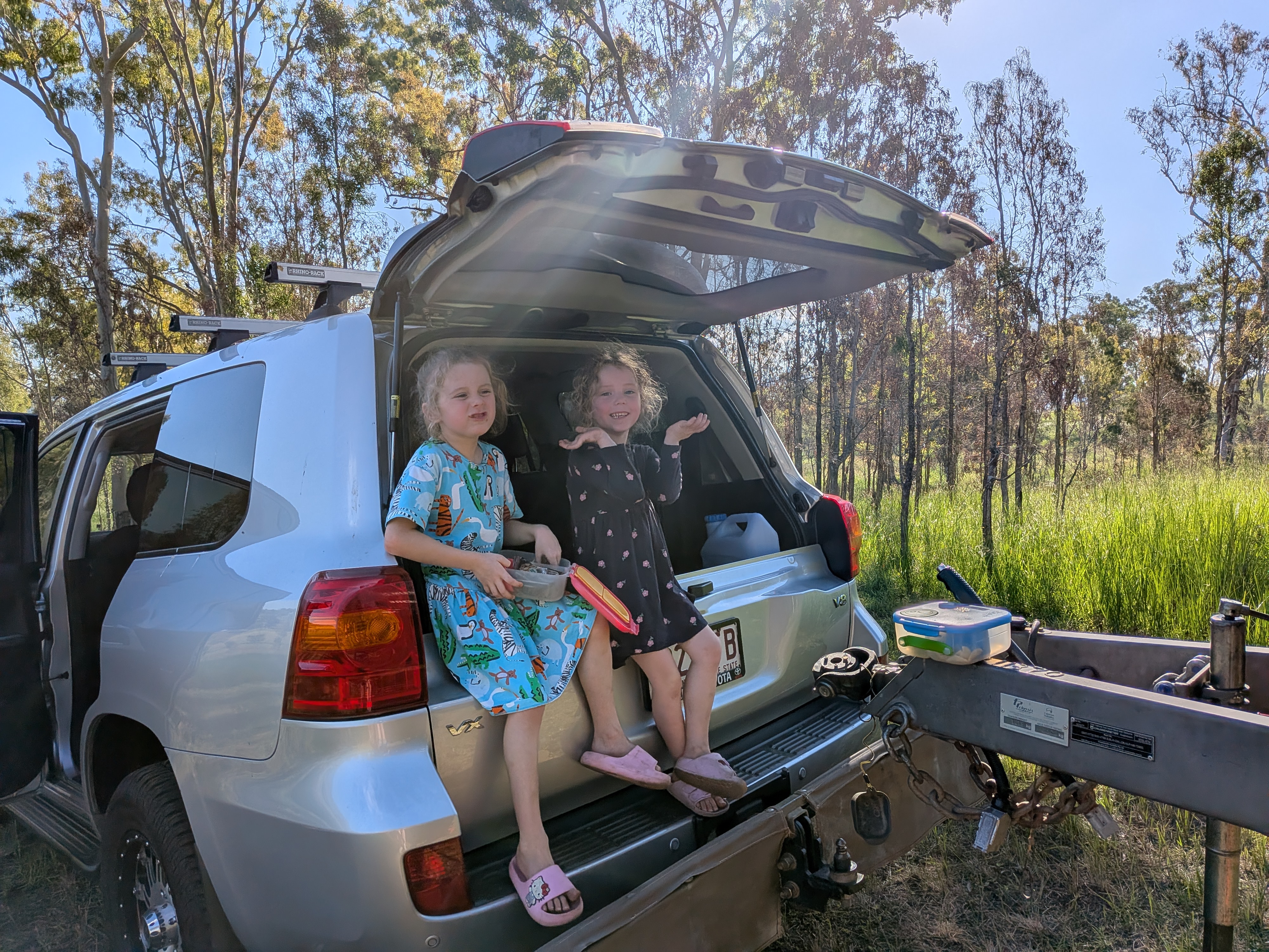 The girls sitting in the boot of the LandCruiser