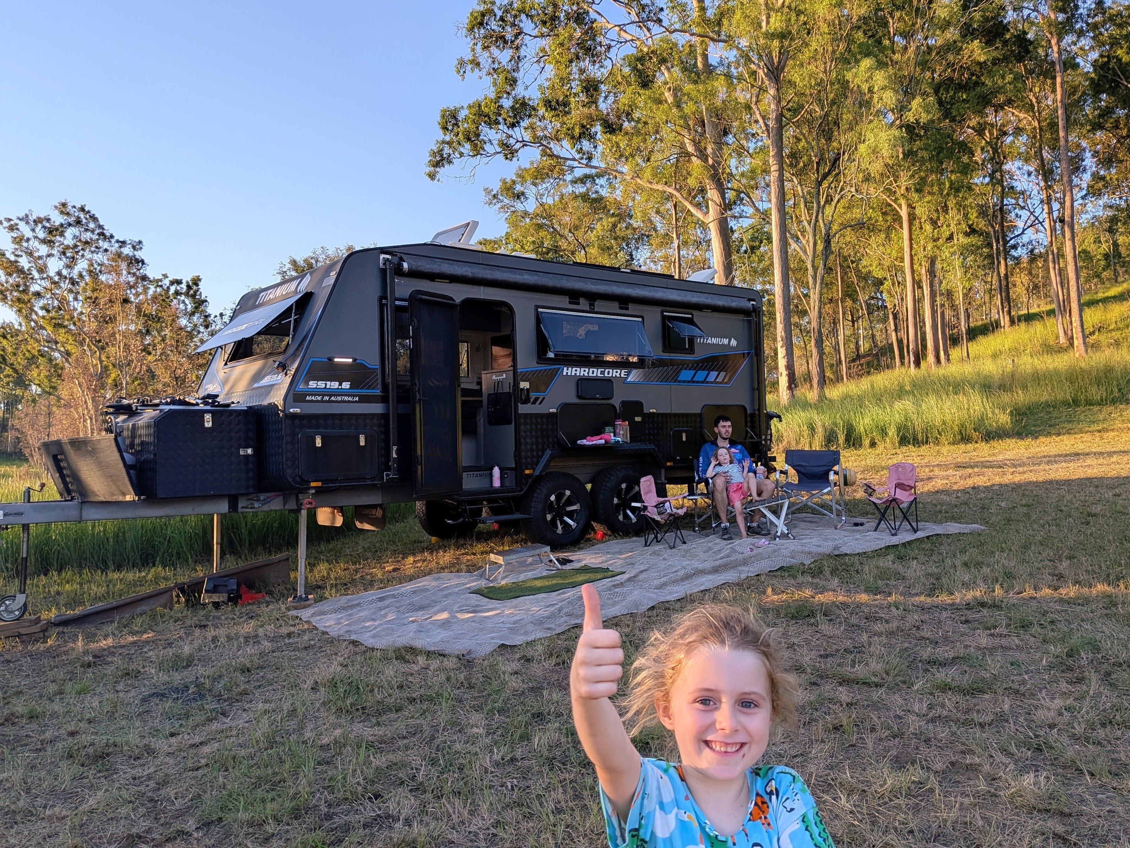 Thumbs up in front of the caravan