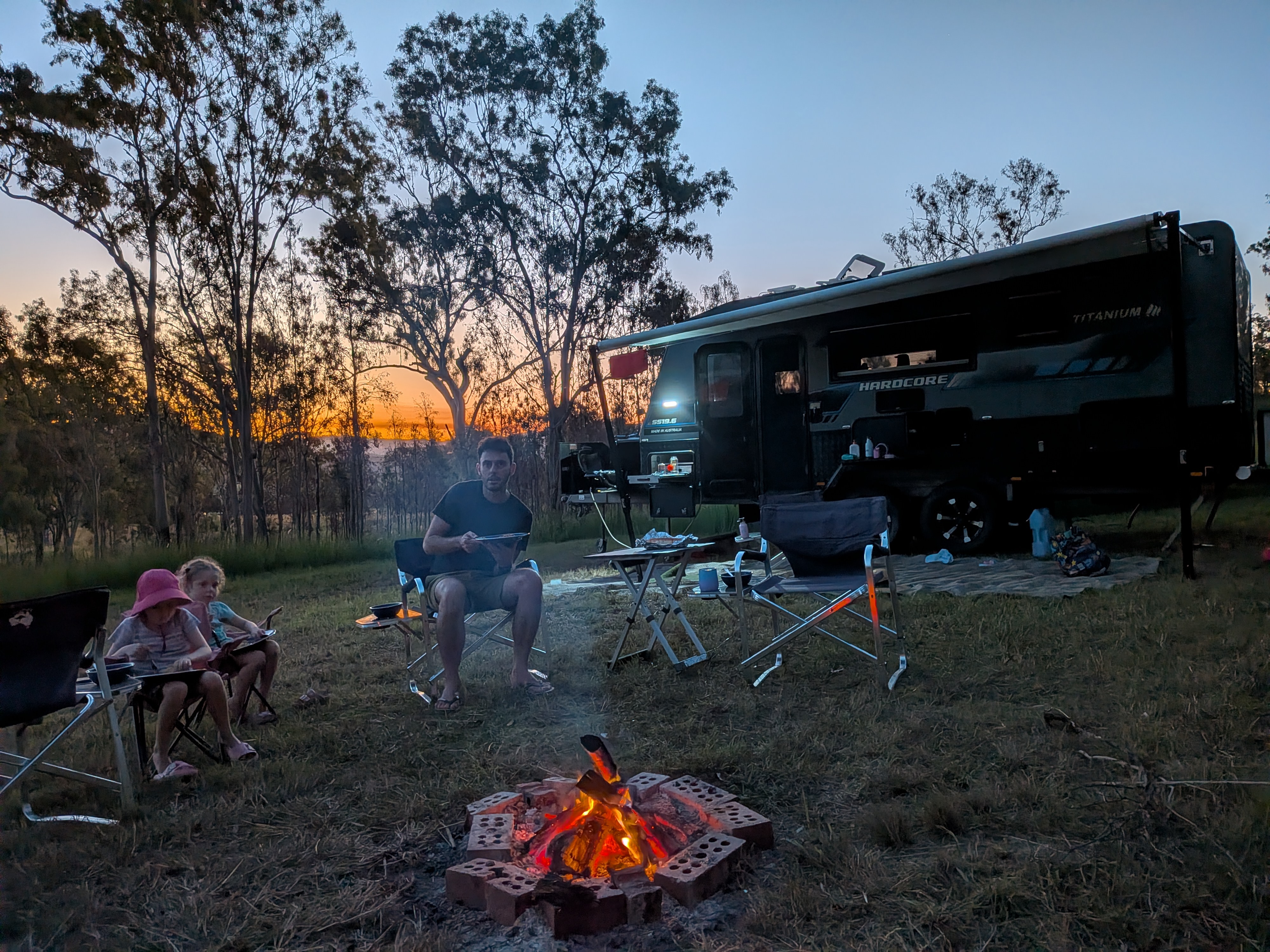 Campfire at dusk by the caravan